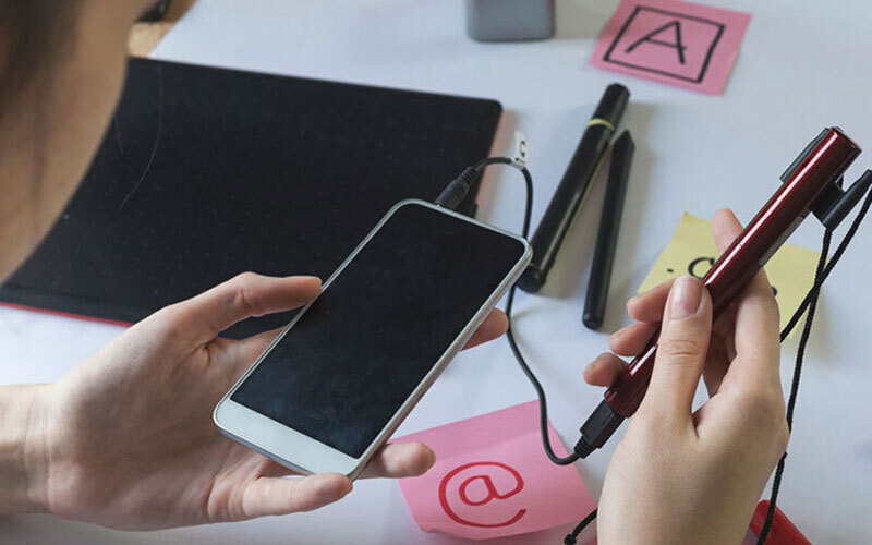 A smartphone with an attached accessibility device.