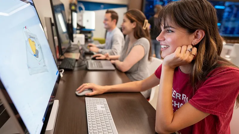 Students sitting at a table using computers.